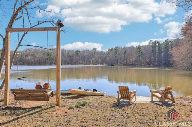 view of dock featuring a water view and a wooded view