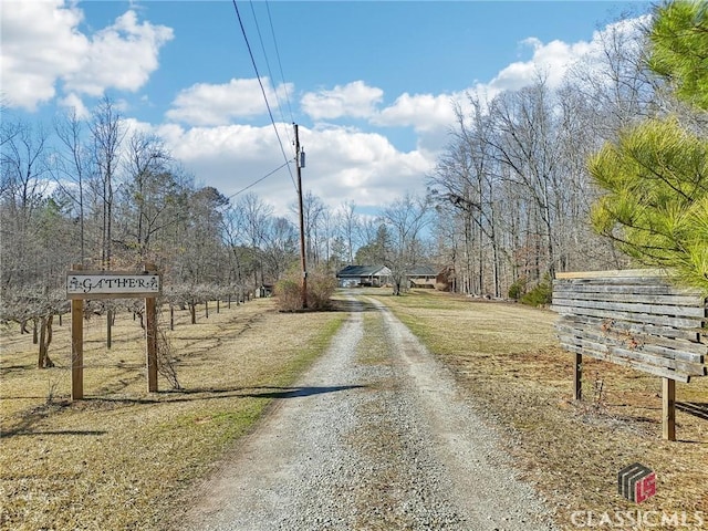 view of street with driveway and a rural view