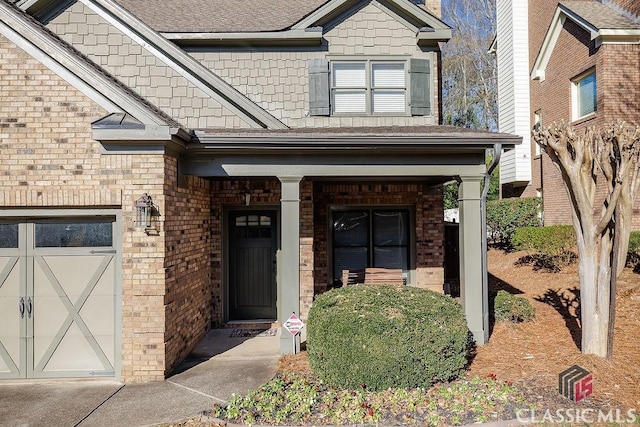 view of exterior entry with a garage and brick siding