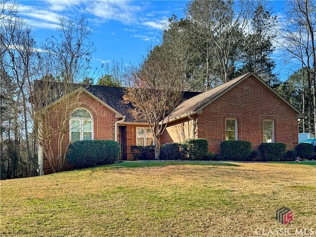 ranch-style home featuring a front yard and brick siding