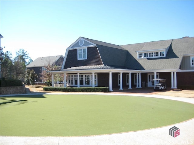 view of front of property with a standing seam roof, metal roof, and a gambrel roof