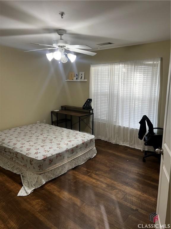 bedroom with ceiling fan, dark wood-type flooring, and visible vents