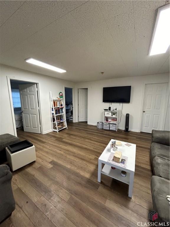 living area with baseboards and wood finished floors