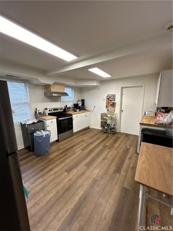 kitchen featuring appliances with stainless steel finishes, white cabinetry, butcher block countertops, and wood finished floors