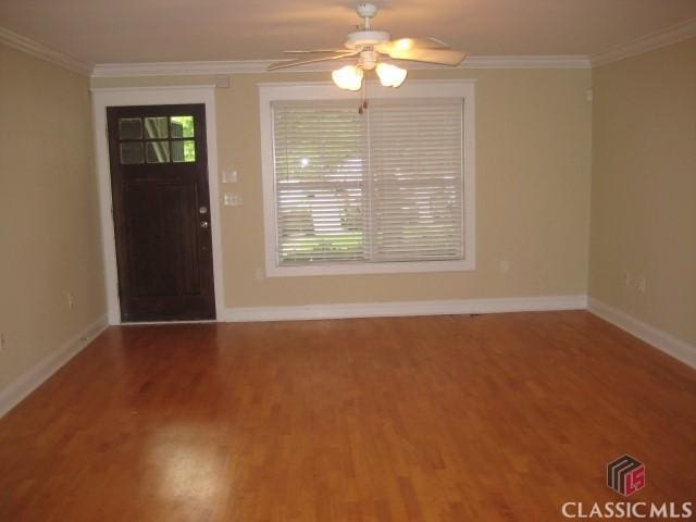 foyer with crown molding, baseboards, and wood finished floors