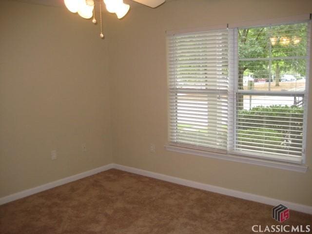 carpeted empty room with baseboards