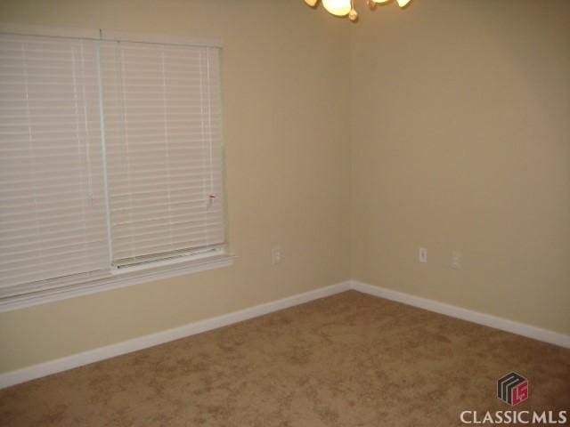 carpeted empty room with baseboards