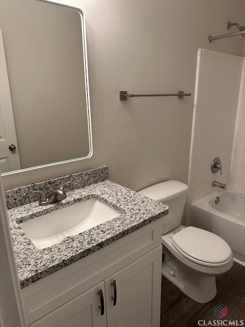 full bath with vanity,  shower combination, wood finished floors, and toilet