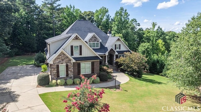 craftsman house featuring brick siding, concrete driveway, board and batten siding, a front yard, and stone siding