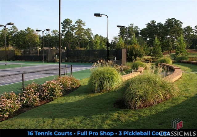 view of sport court with fence and a lawn