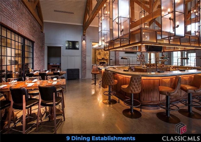 bar featuring brick wall and a high ceiling