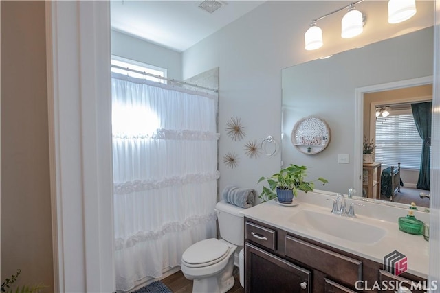 full bath with toilet, vanity, visible vents, and a shower with curtain