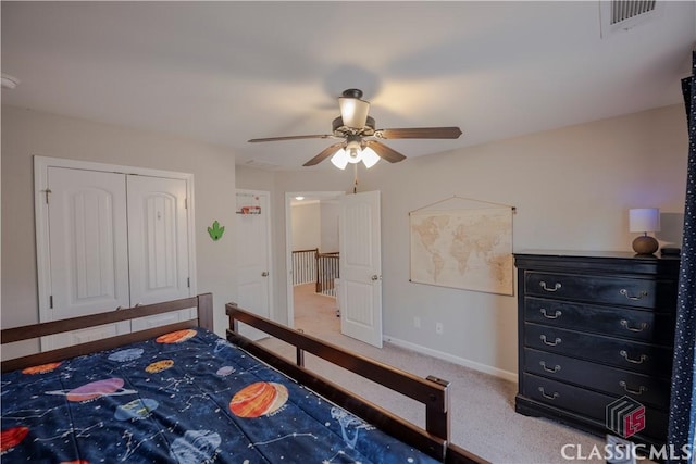 carpeted bedroom featuring ceiling fan, a closet, visible vents, and baseboards