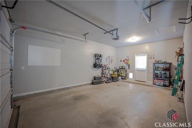 garage featuring a garage door opener and baseboards