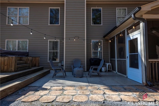 view of patio with a sunroom and a hot tub