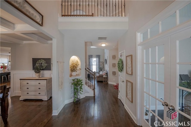 foyer with stairs, visible vents, beamed ceiling, and hardwood / wood-style flooring