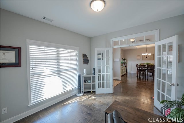 interior space with hardwood / wood-style flooring, visible vents, a chandelier, and french doors