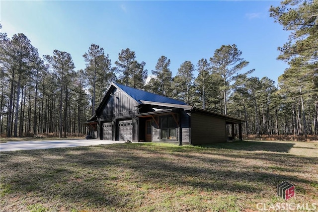 exterior space with a garage, metal roof, and a yard