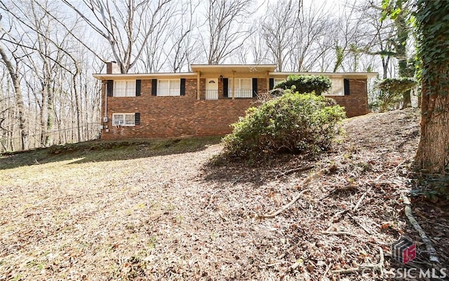 ranch-style home with brick siding and a chimney