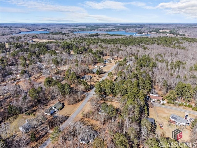 aerial view with a water view and a wooded view