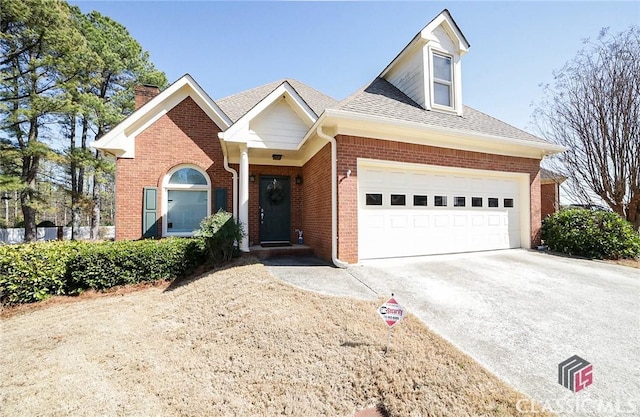 view of front of house with concrete driveway, brick siding, an attached garage, and roof with shingles