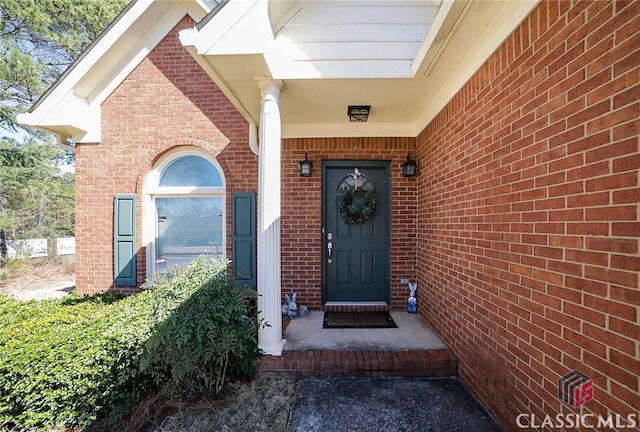 doorway to property featuring brick siding