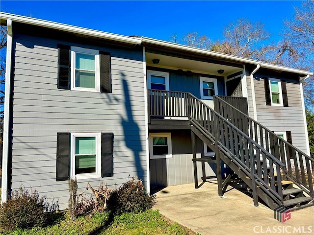 back of property featuring a patio area and stairs