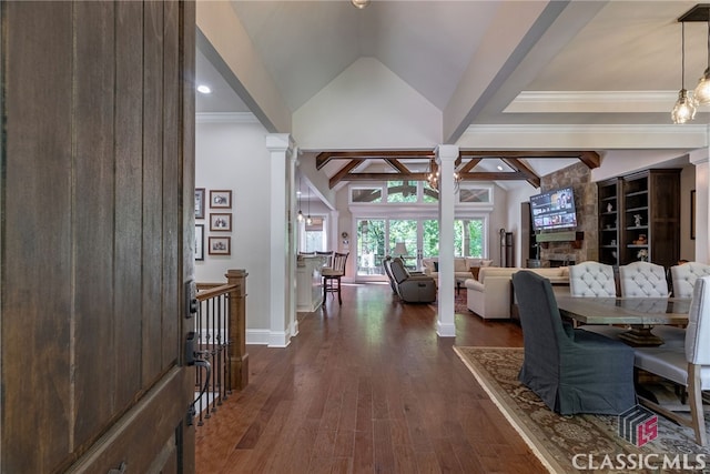 interior space with dark wood-style flooring, baseboards, vaulted ceiling with beams, and ornate columns