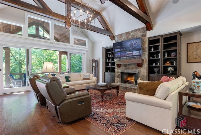 living area featuring high vaulted ceiling, a fireplace, wood finished floors, beamed ceiling, and an inviting chandelier