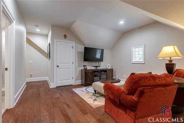 living room with lofted ceiling, recessed lighting, wood finished floors, and baseboards