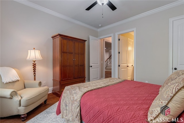 bedroom featuring baseboards, a ceiling fan, ensuite bath, wood finished floors, and crown molding