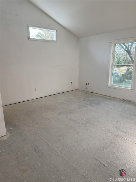 unfurnished room with vaulted ceiling