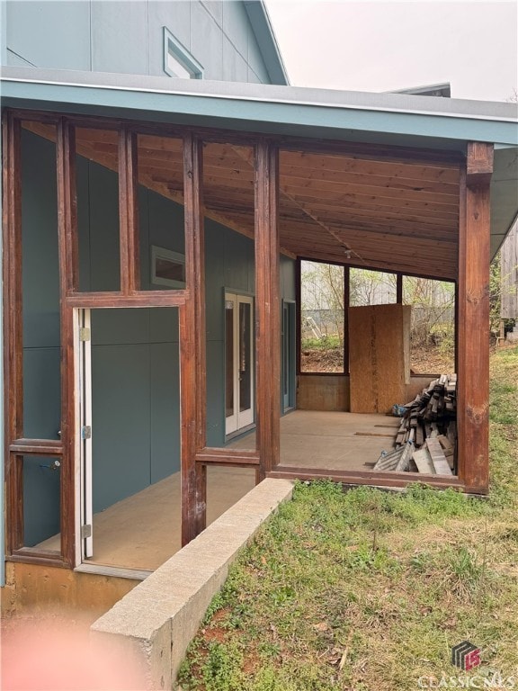 view of exterior entry with board and batten siding and french doors