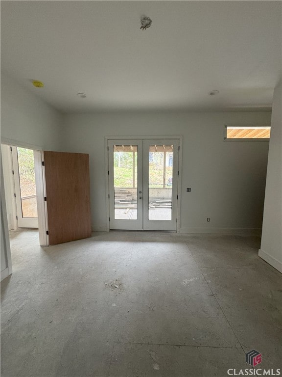 spare room featuring french doors and baseboards