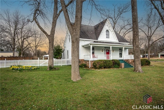 view of front of property featuring covered porch, a front yard, and fence