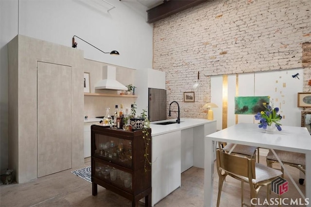 kitchen with a sink, light countertops, appliances with stainless steel finishes, custom exhaust hood, and open shelves