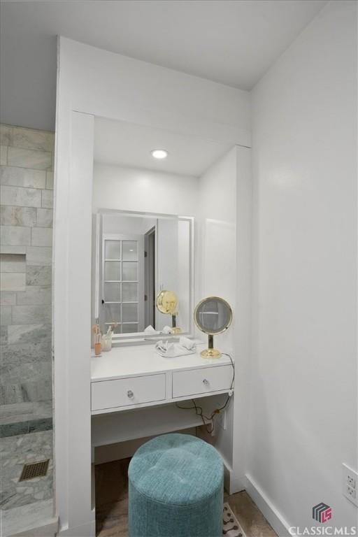 laundry area featuring laundry area, stacked washing maching and dryer, and baseboards