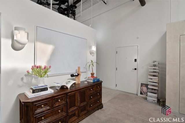 living area with concrete floors and a towering ceiling