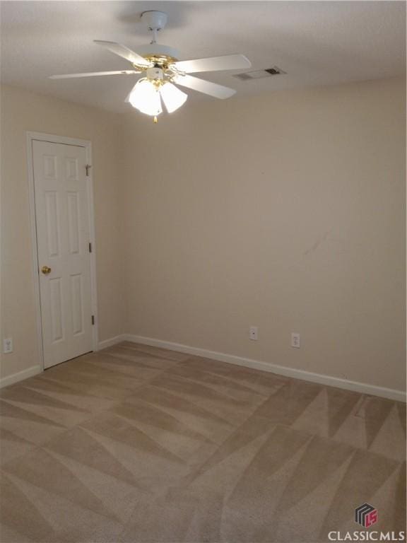 empty room featuring baseboards, visible vents, a ceiling fan, and light colored carpet