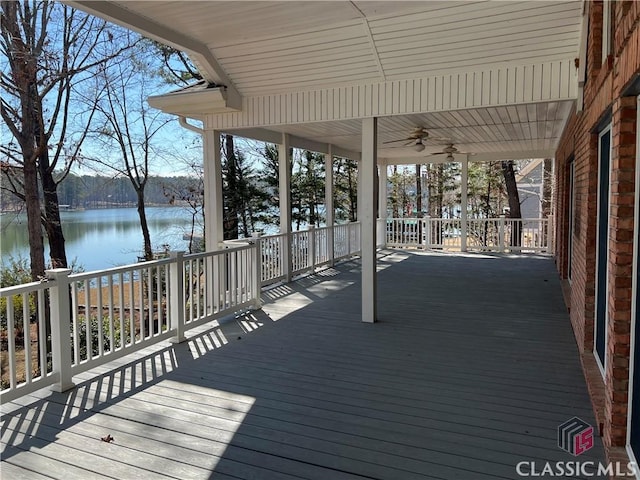 wooden deck with a water view and a ceiling fan