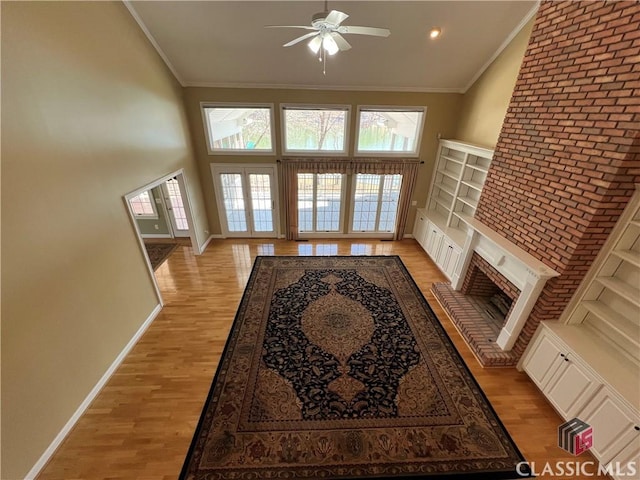 living room featuring ornamental molding, a fireplace, and light wood finished floors