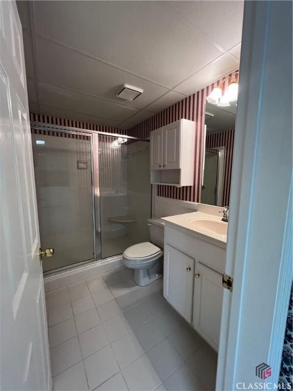 bathroom featuring toilet, a stall shower, tile patterned floors, and vanity