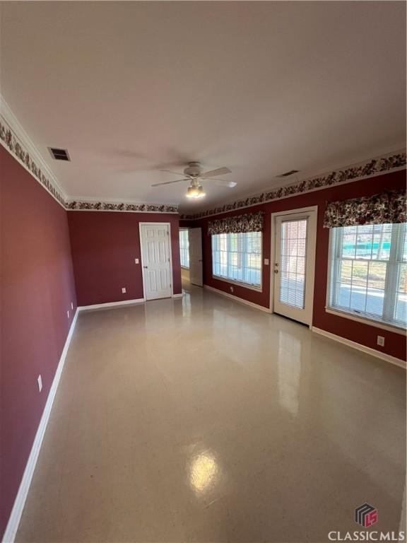 spare room featuring ceiling fan, visible vents, and baseboards