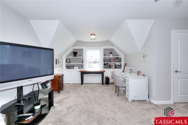 office featuring light carpet, built in shelves, baseboards, and vaulted ceiling