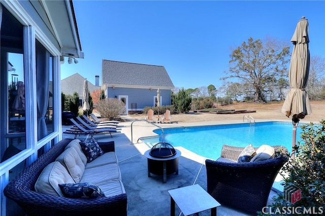 outdoor pool with a patio area and an outdoor fire pit