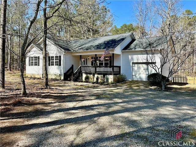 view of front facade featuring a porch, driveway, a shingled roof, and an attached garage