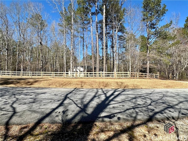 exterior space with fence and a wooded view