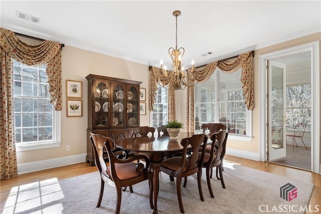 dining area with baseboards, a chandelier, visible vents, and light wood-style floors