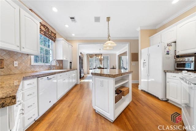 kitchen featuring visible vents, a sink, light wood-style floors, ornamental molding, and white appliances