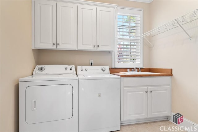 laundry area featuring a sink, cabinet space, and washer and dryer